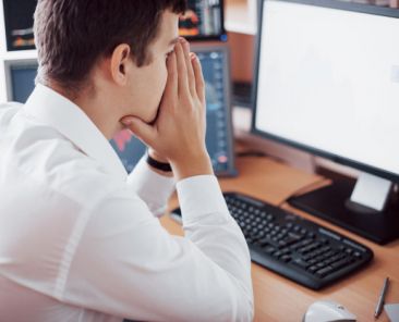 stressful-day-office-young-businessman-holding-hands-his-face-while-sitting-desk-creative-office-stock-exchange-trading-forex-finance-graphic-concept_146671-15021